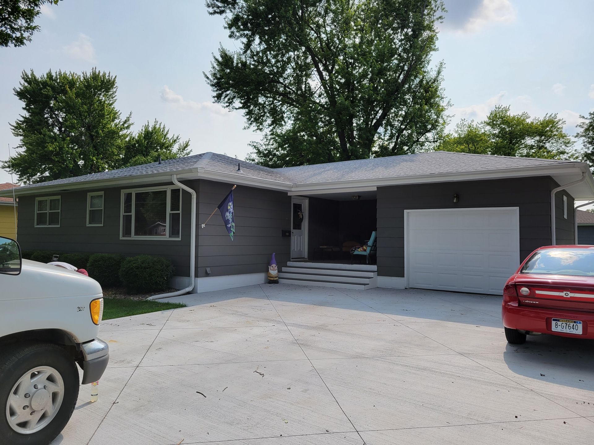 A red car is parked in front of a house