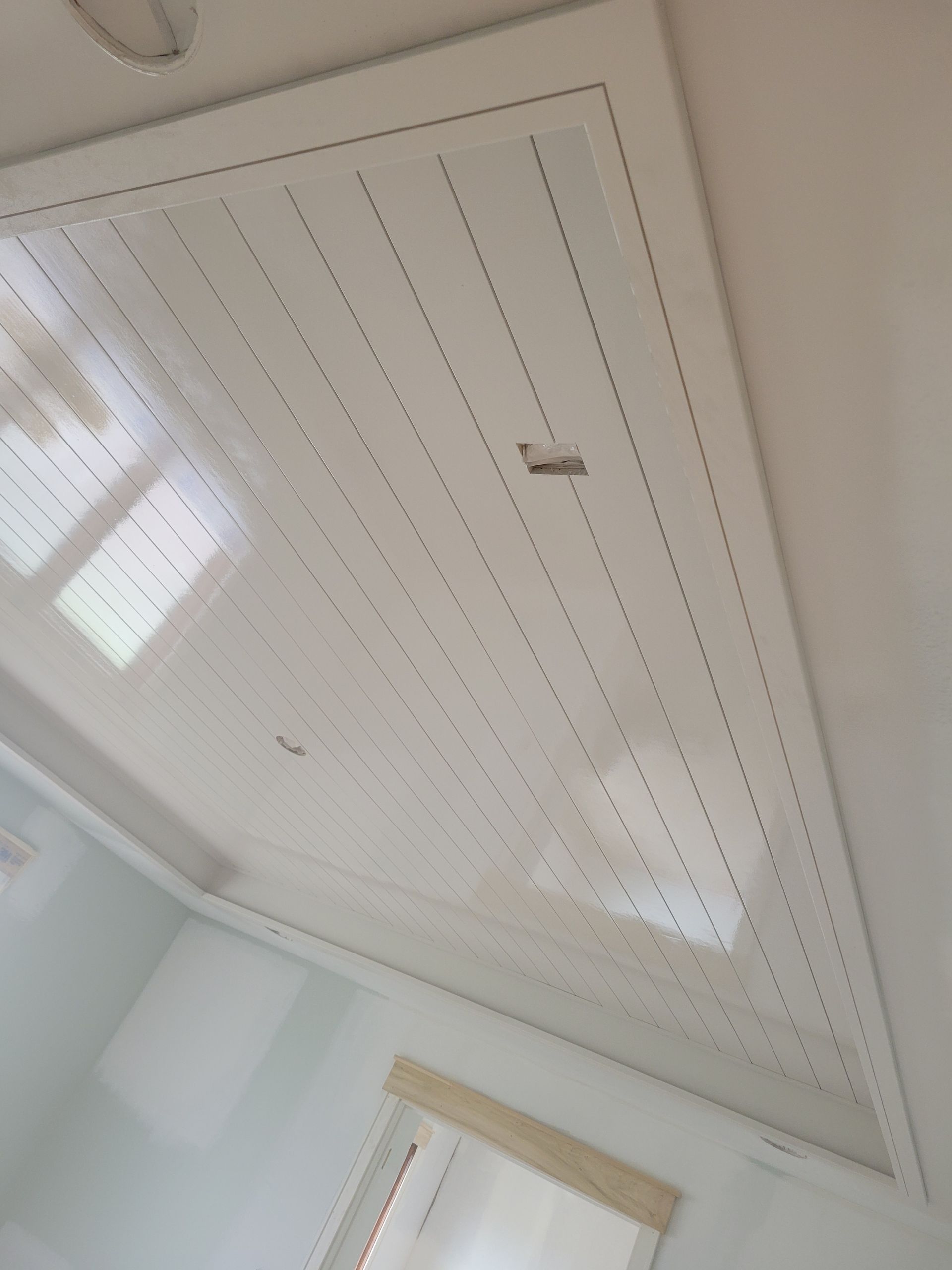 A white ceiling in a room with a window.