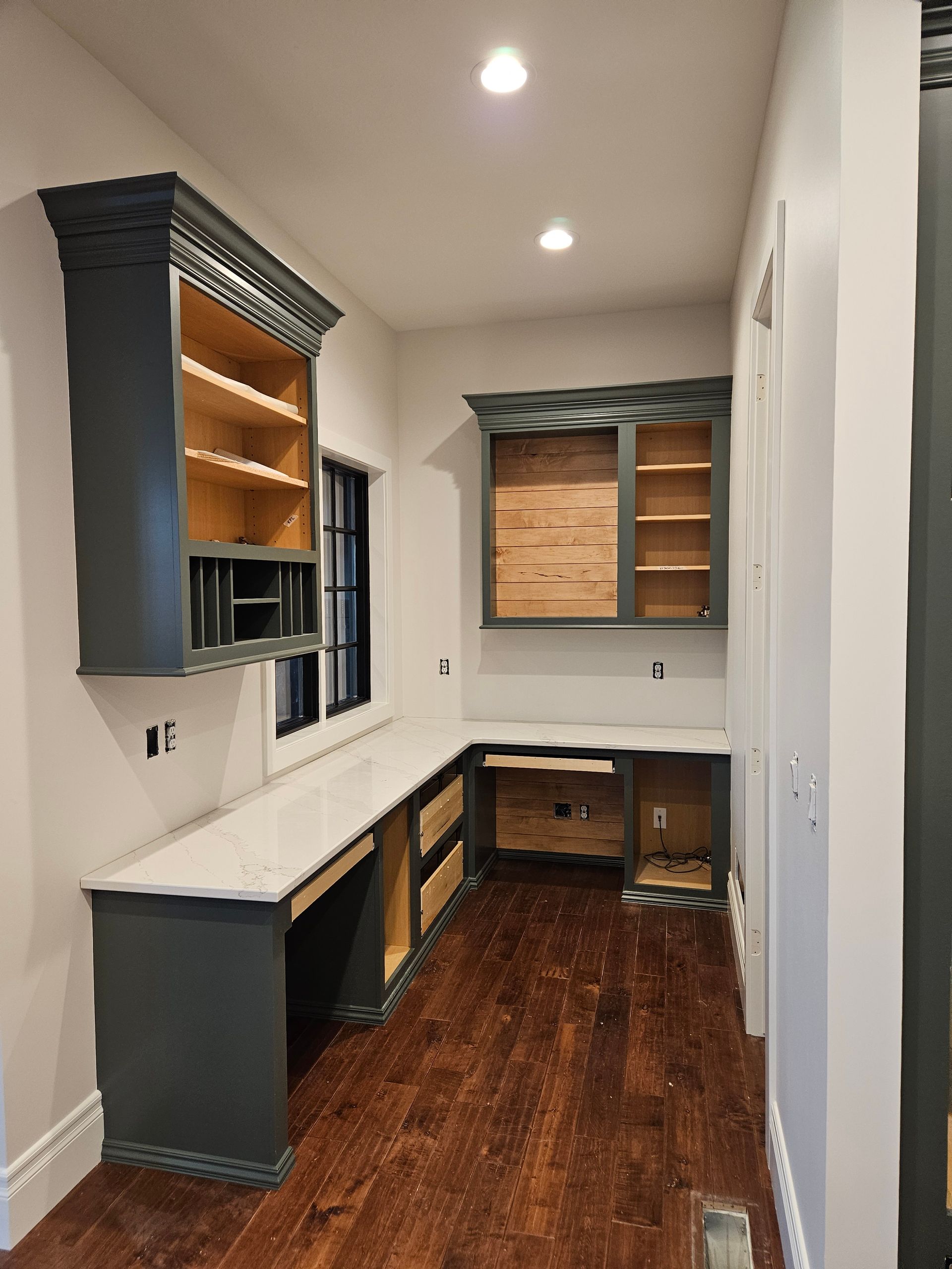 A room with a desk and shelves in it.