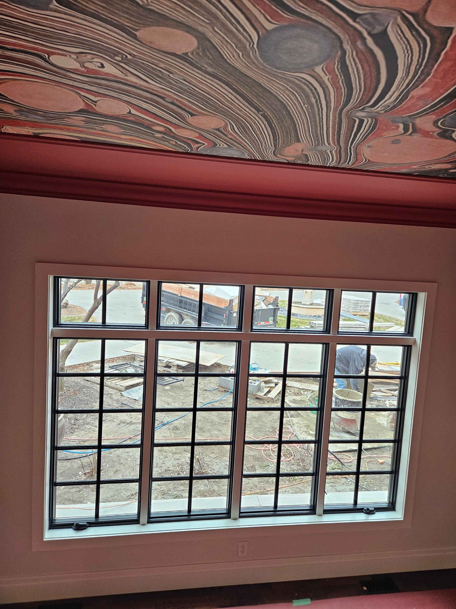 A room with a window and a painting on the ceiling