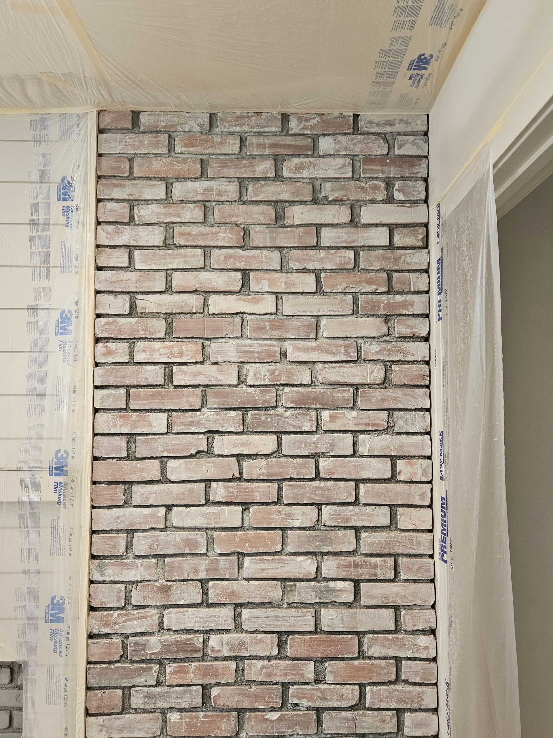 A brick wall is being built in a room.