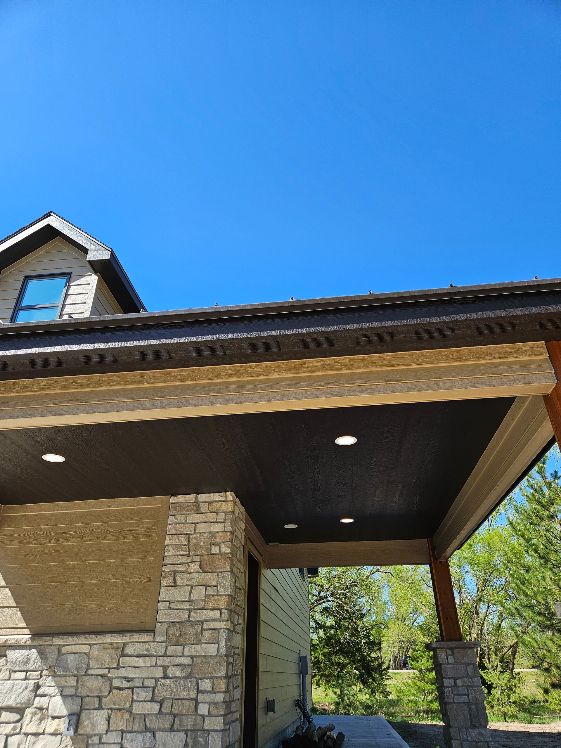 A house with a porch and a blue sky in the background.