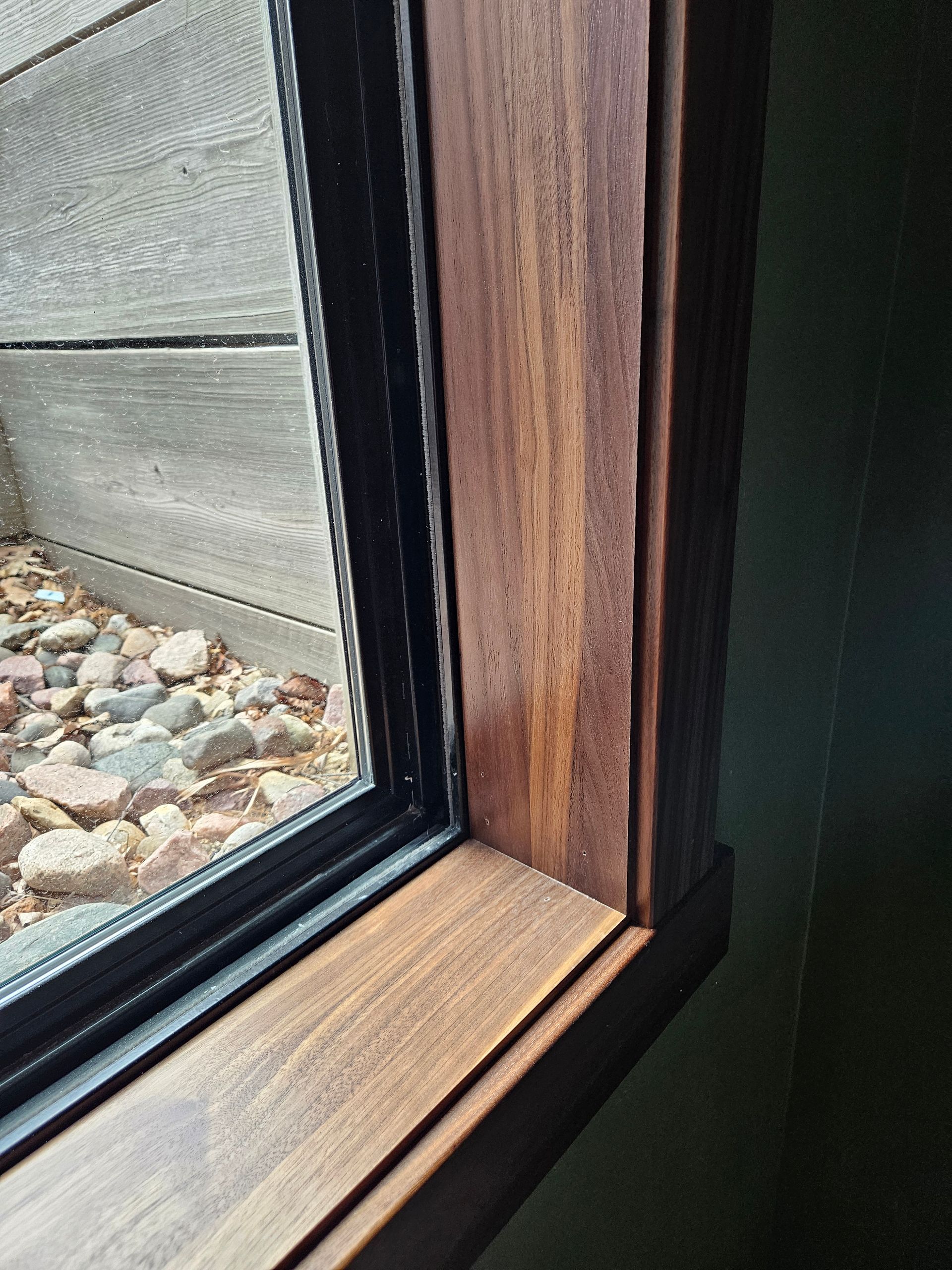 A close up of a window with a wooden frame and a glass window.