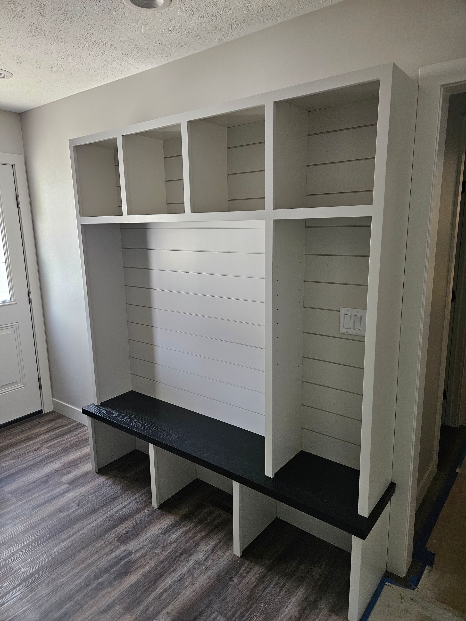 A room with a bench and shelves in it.