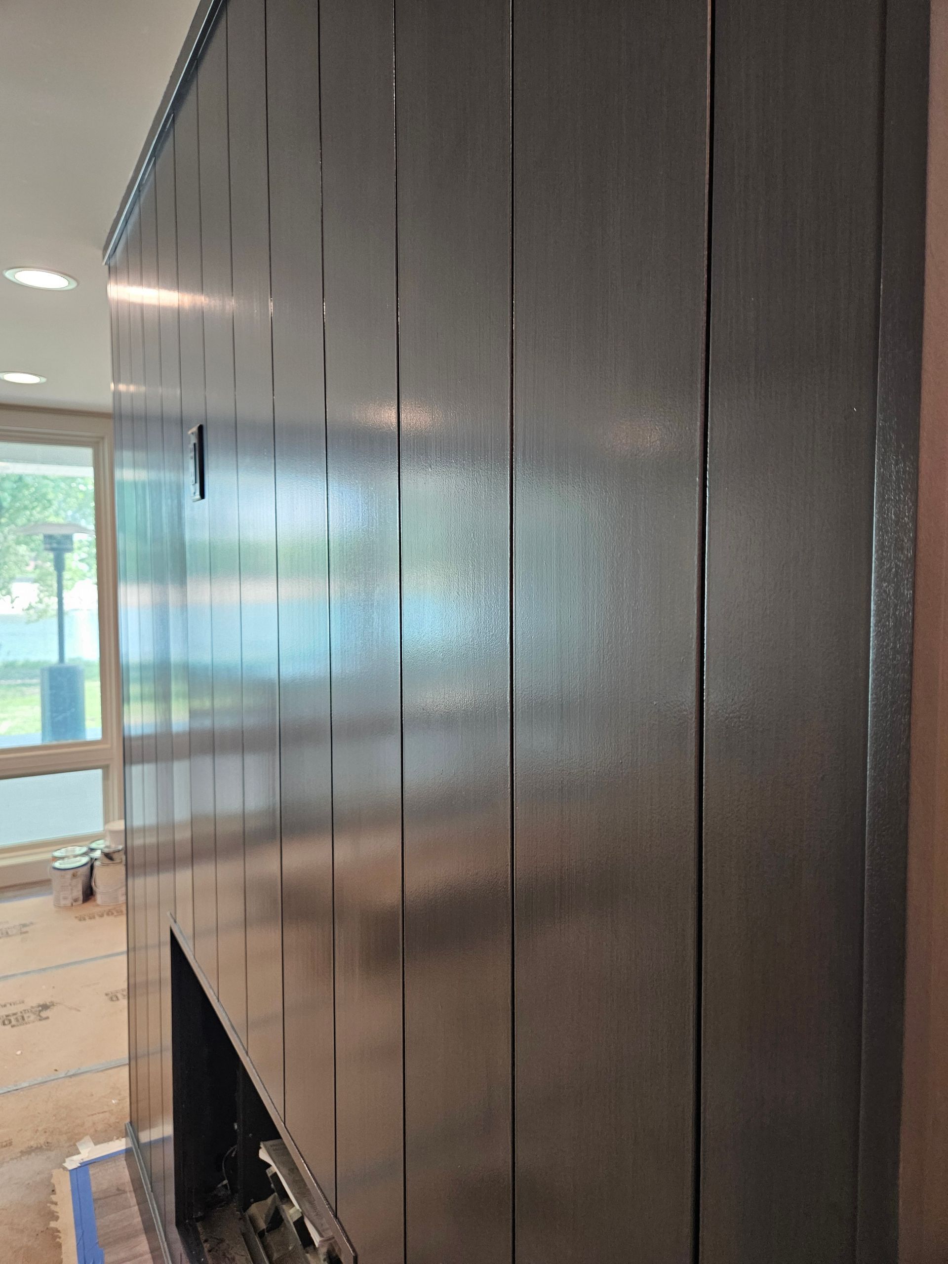 A stainless steel fireplace is being built in a living room.