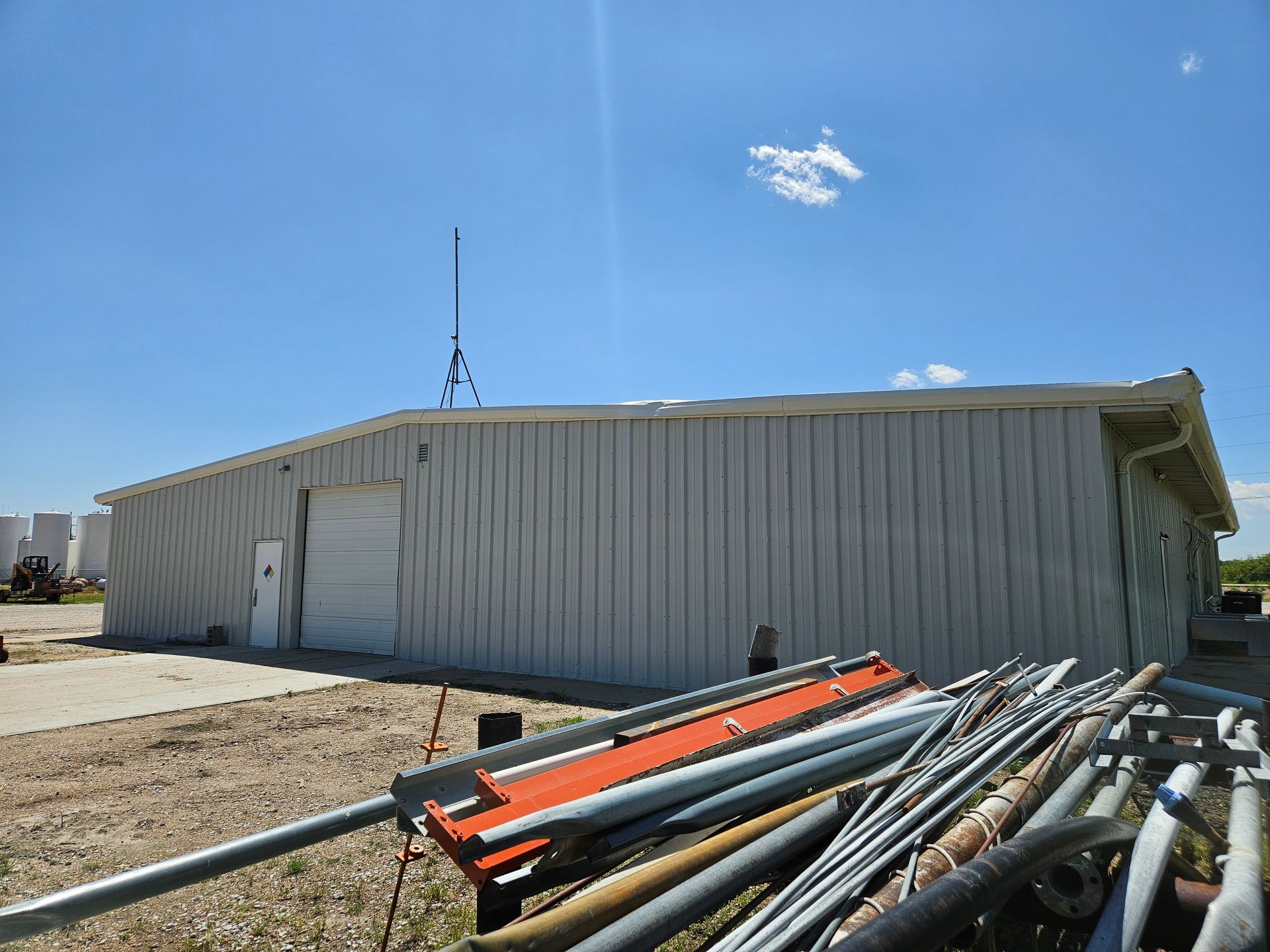 A large white building with a lot of pipes in front of it.