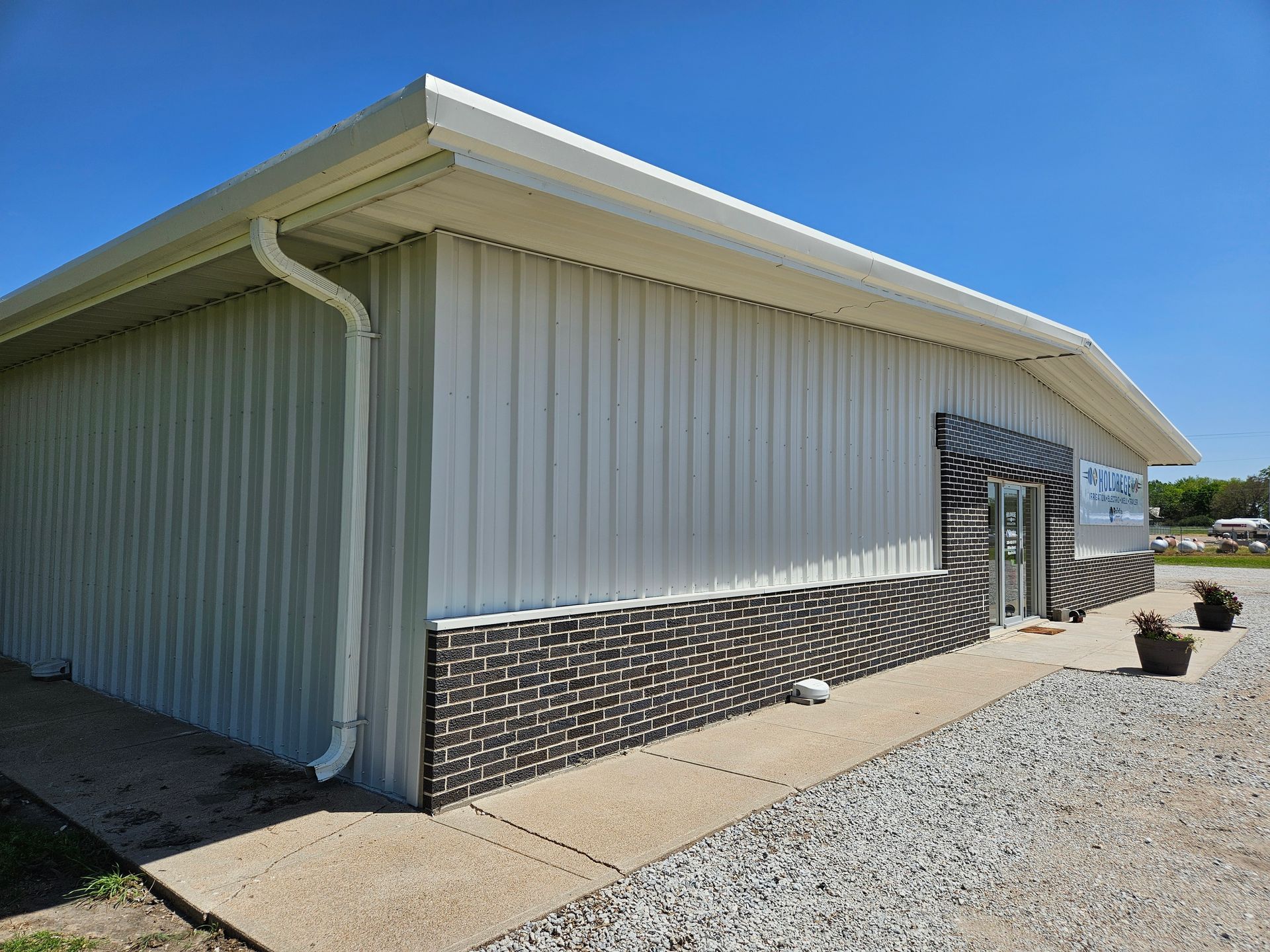 A large white building with a gutter on the side of it.