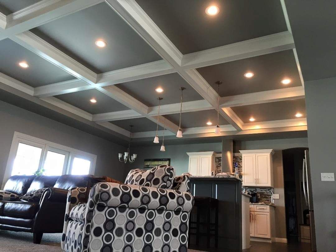A living room with a coffered ceiling and a couch and chair