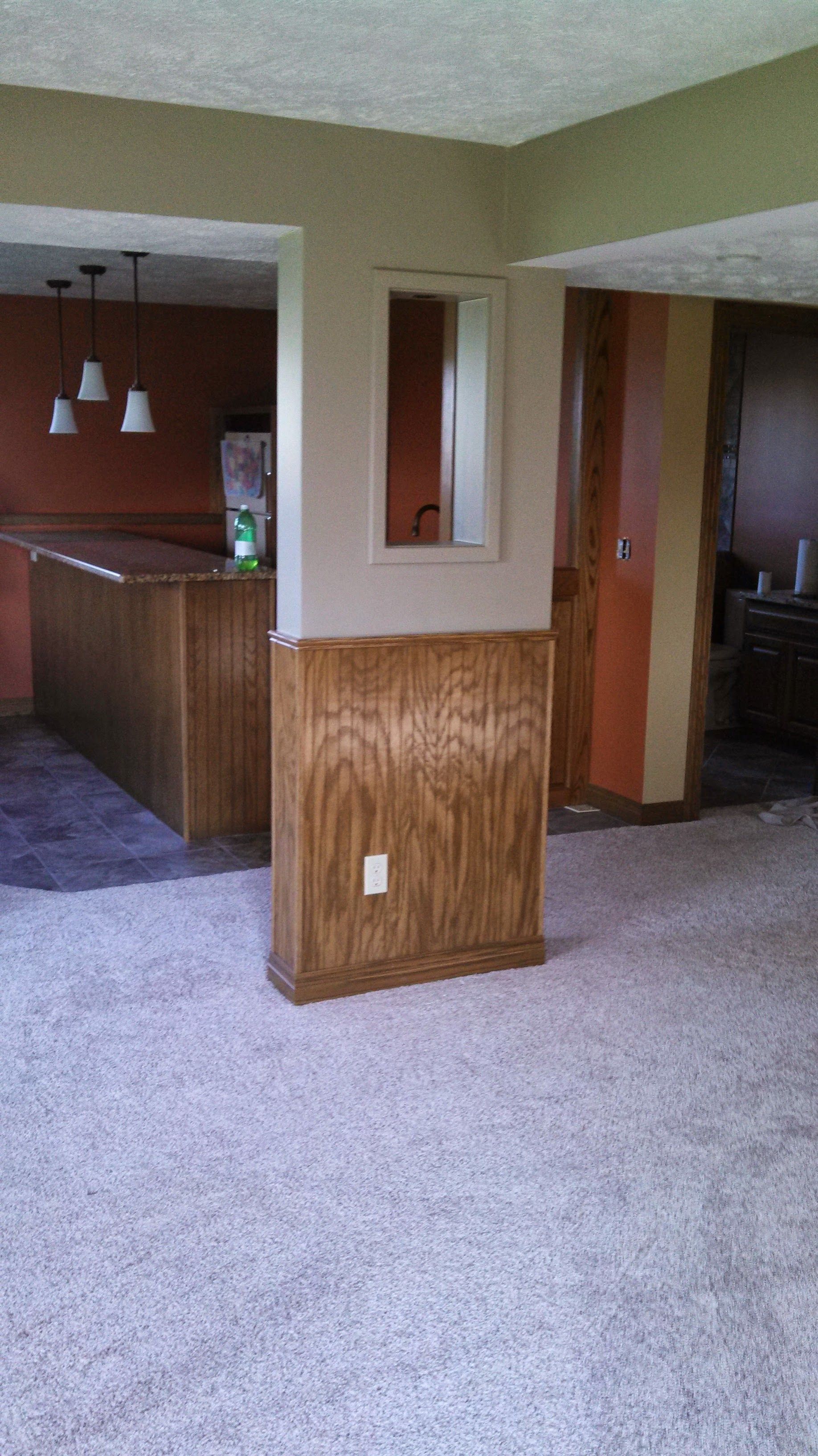 An empty room with a carpeted floor and a mirror on the wall.