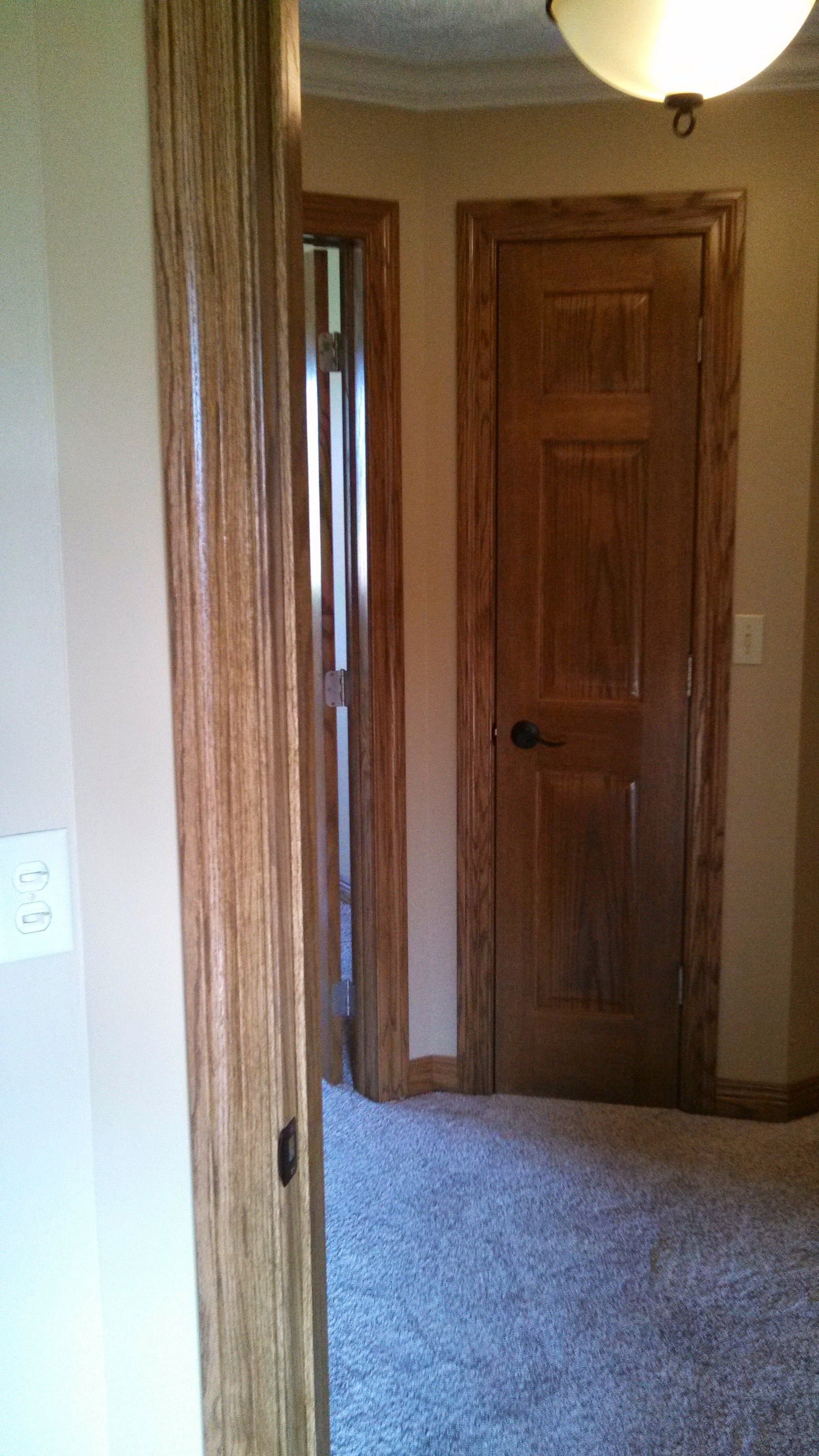 A hallway with a wooden door and a carpeted floor.