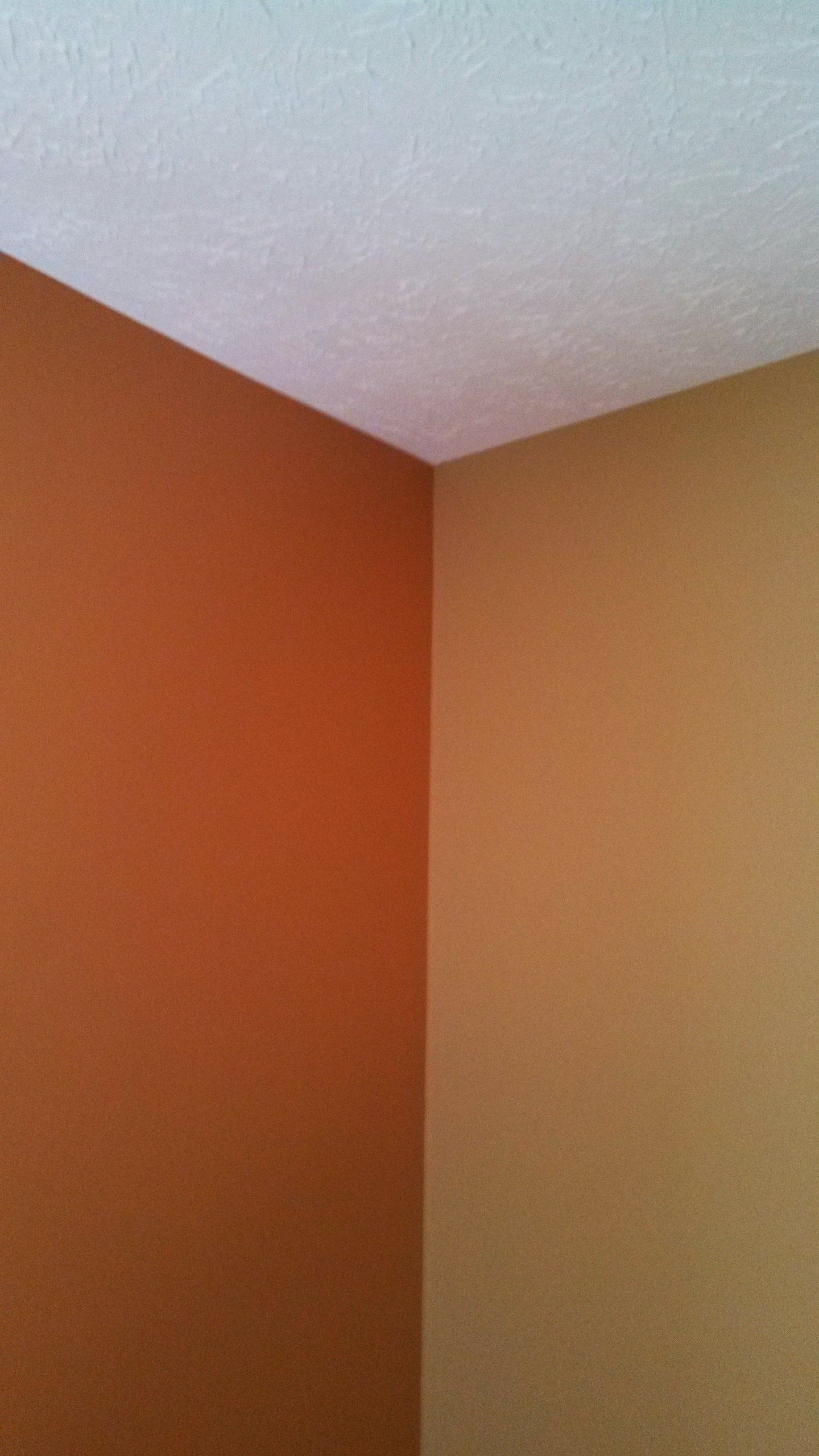 A corner of a room with orange and tan walls and a white ceiling.