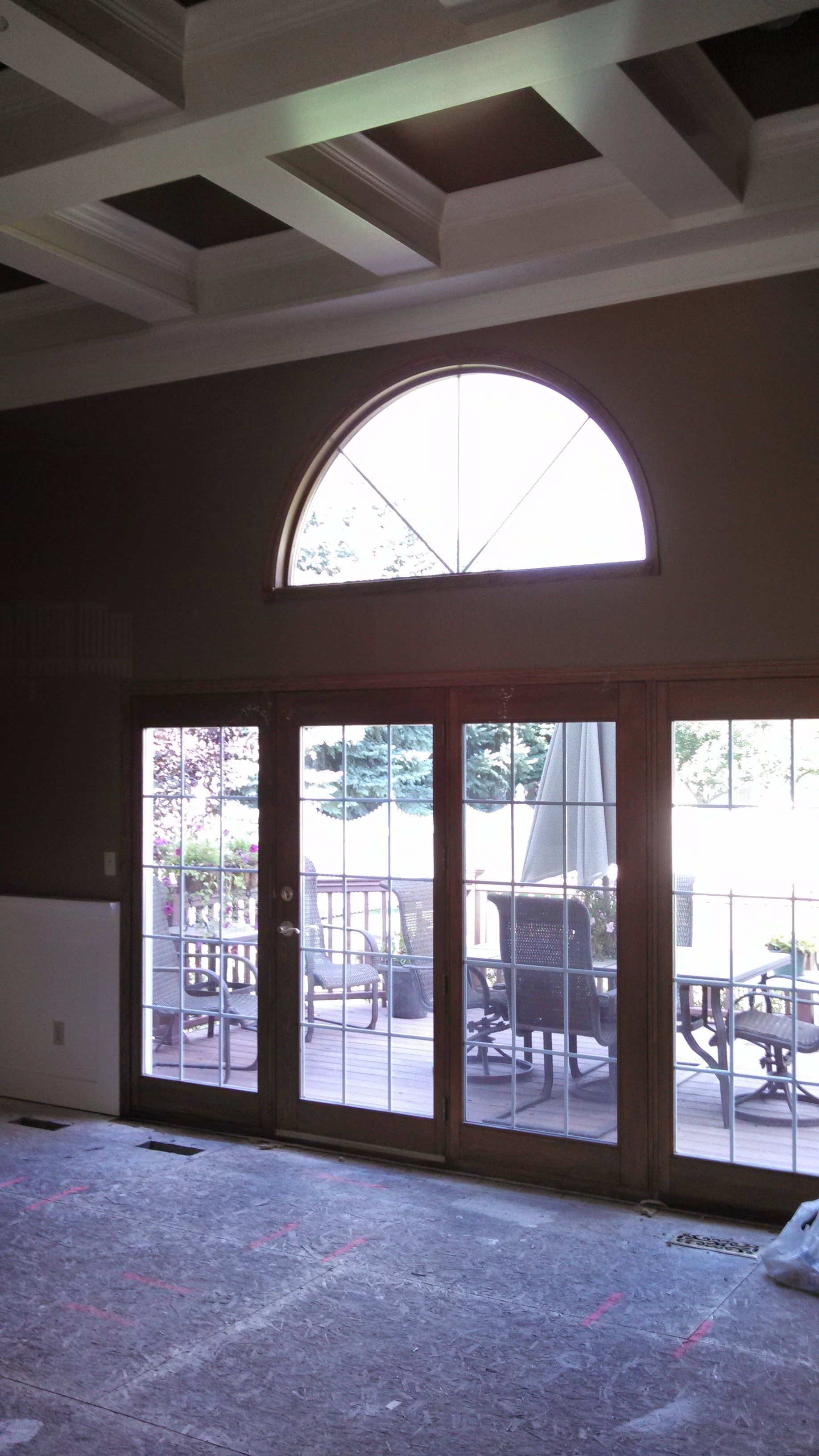 An empty room with a large window and sliding glass doors