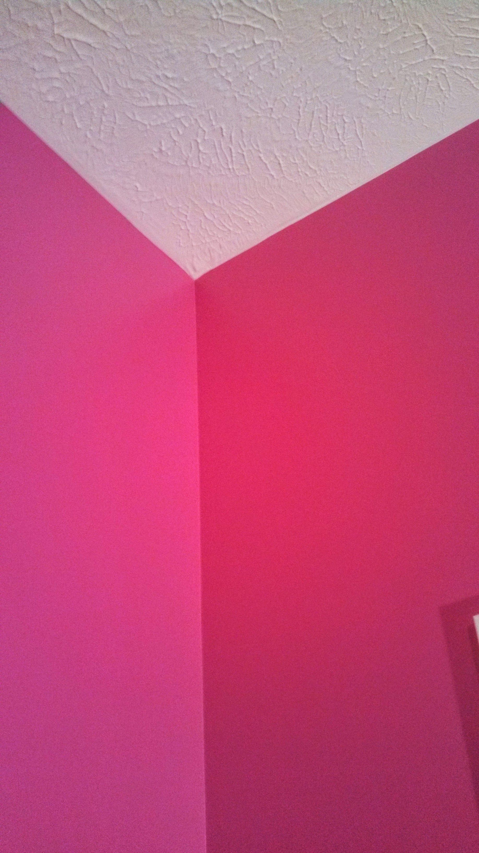 A corner of a room with pink walls and a white ceiling.