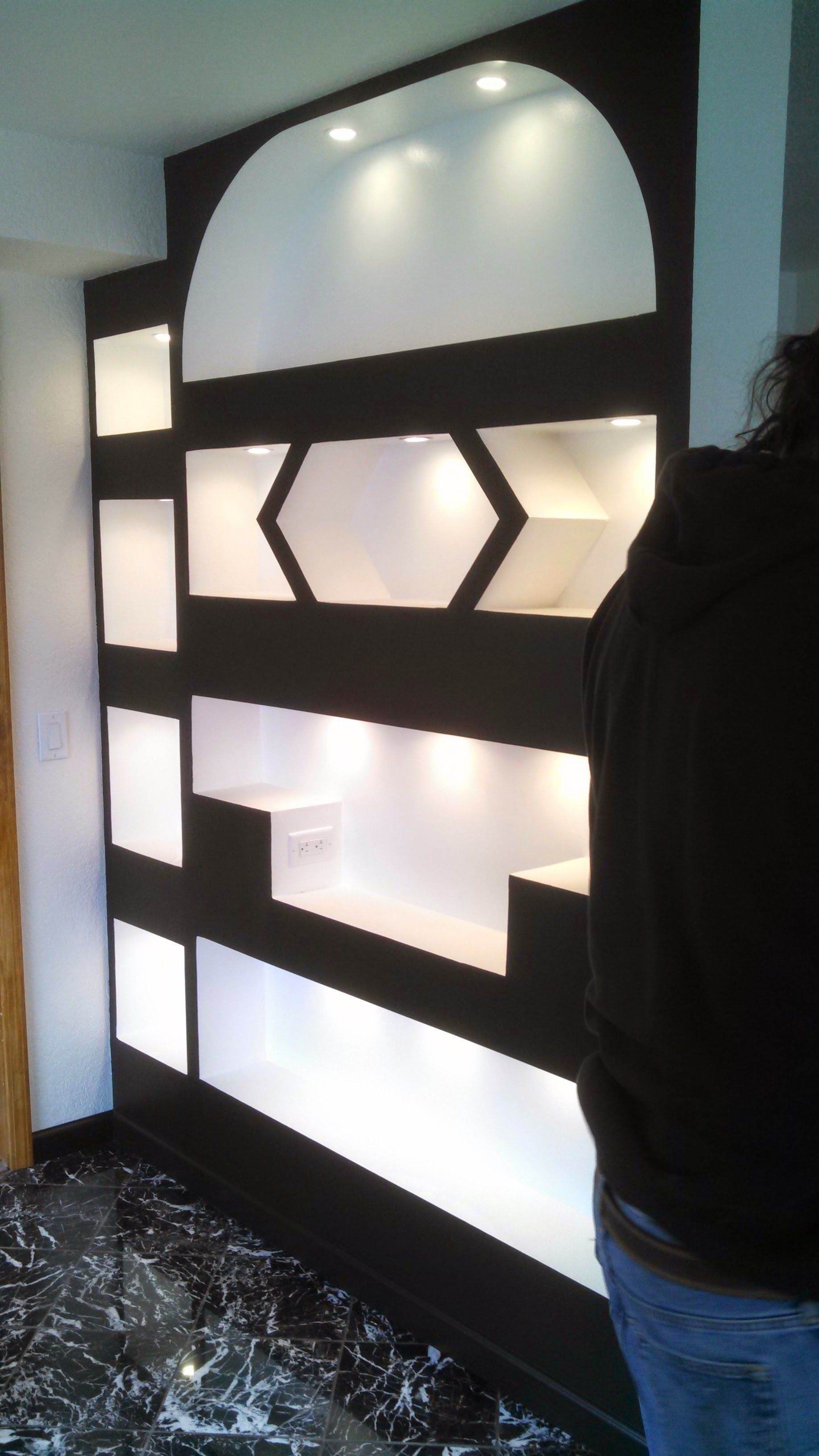 A person standing in front of a black and white wall