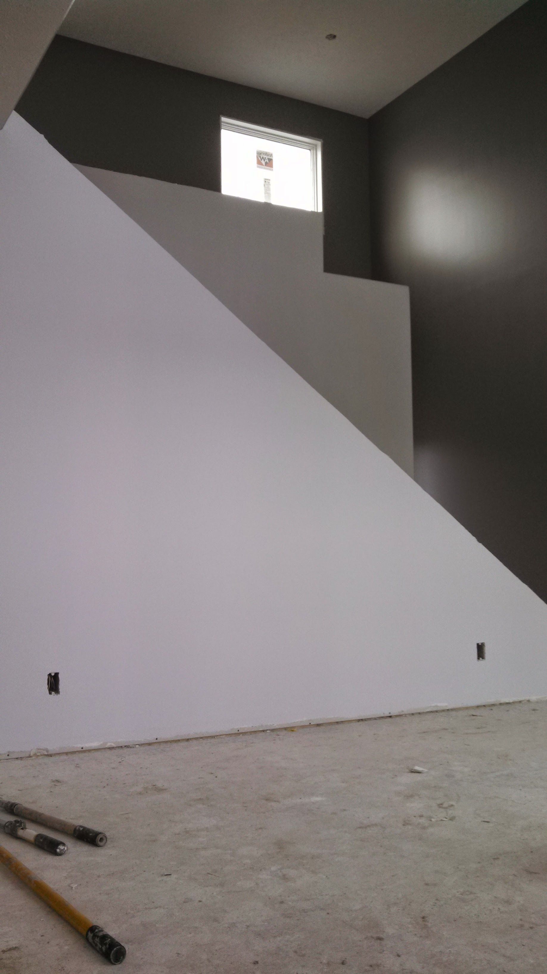A room with a staircase and a white wall.