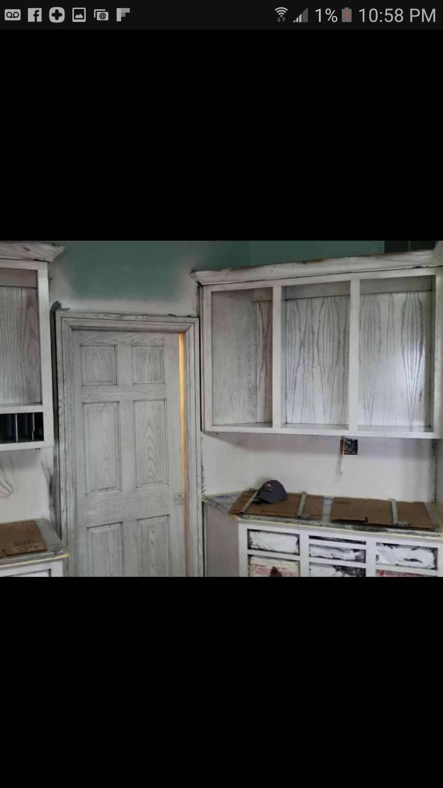 A kitchen with white cabinets and a door.
