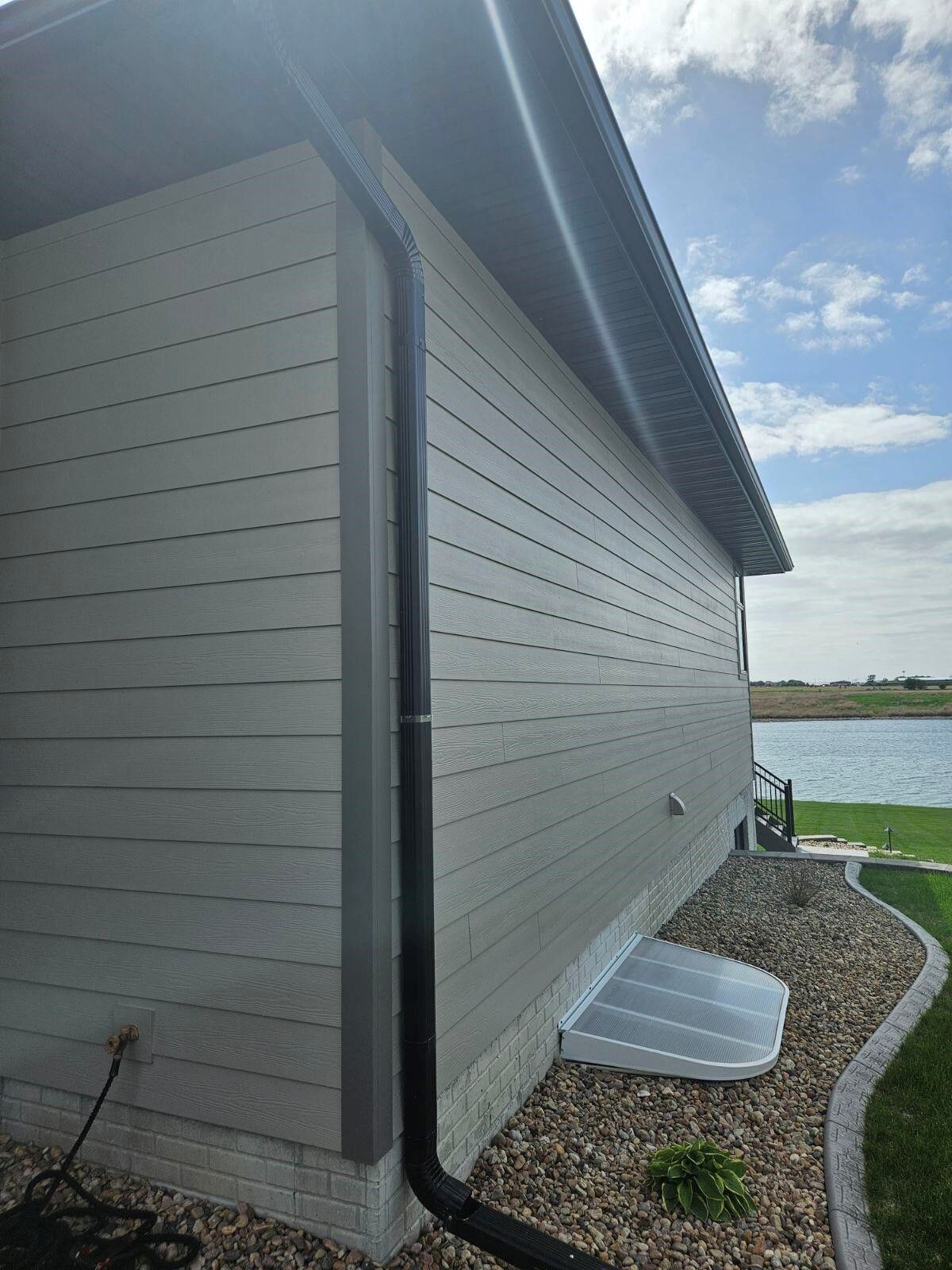 A house with a black gutter on the side of it.