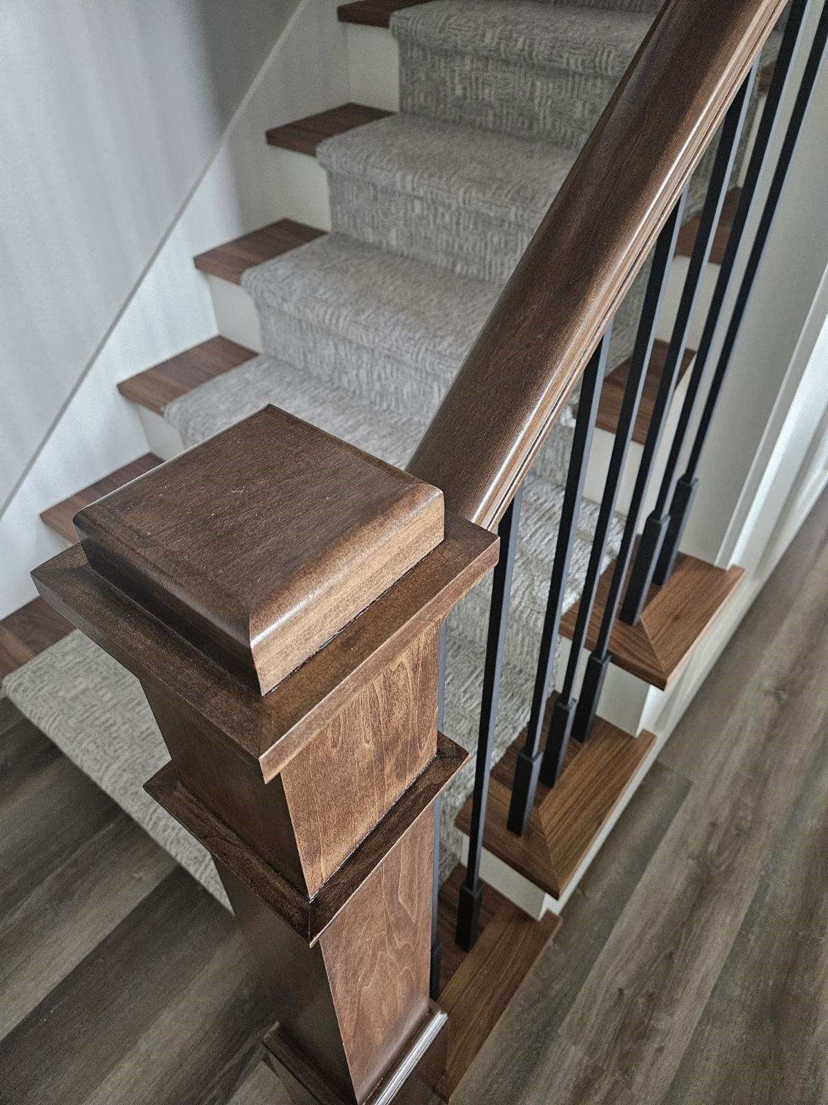 A staircase with a wooden railing and a carpeted staircase.