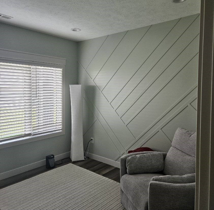 A living room with a couch , chair , rug and window.