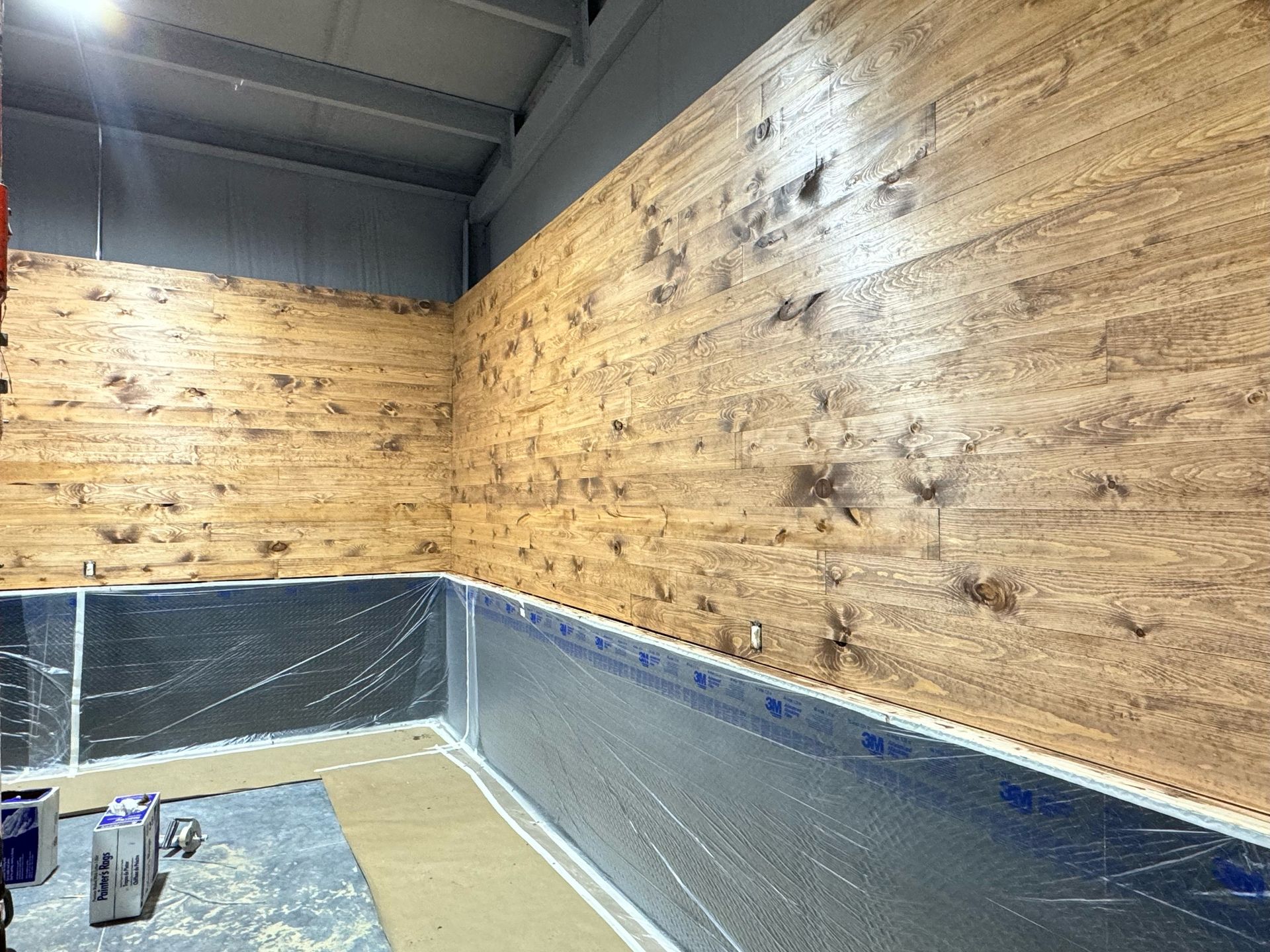 A room with a wooden wall and a metal wall.