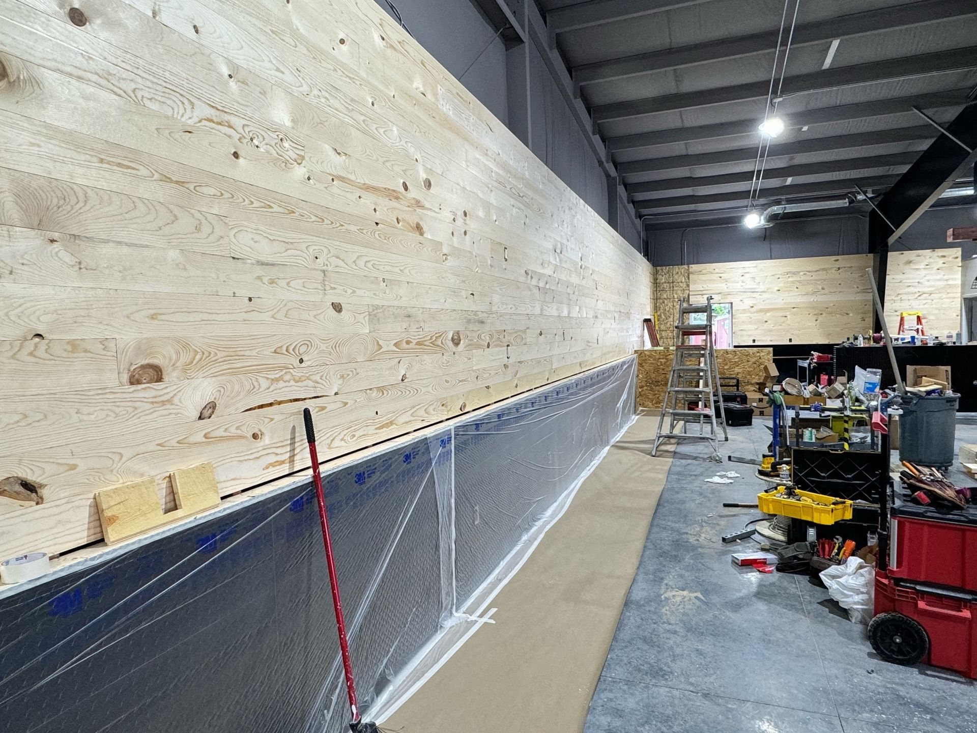 A large wooden wall is being built in a building.