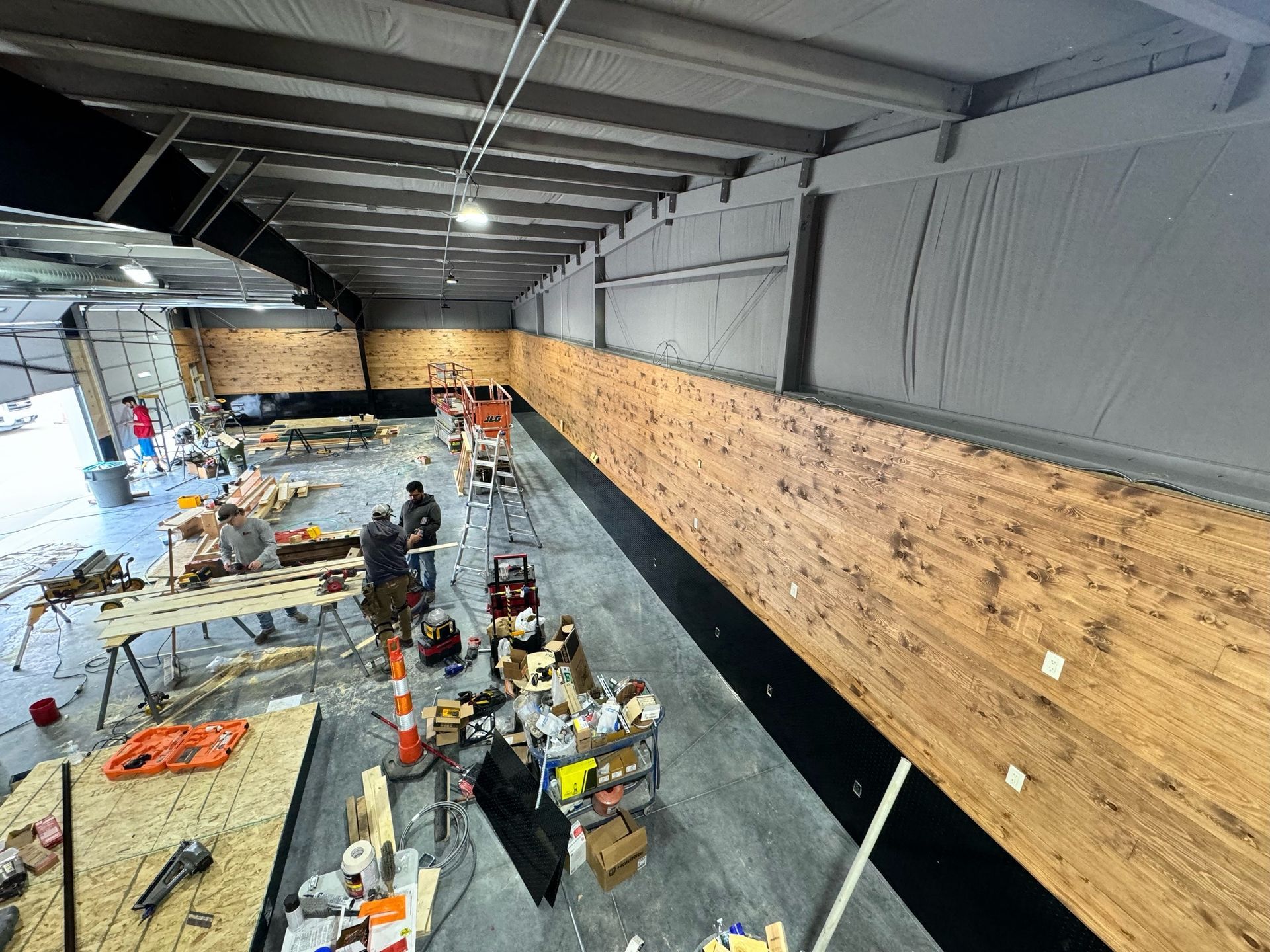 An aerial view of a building under construction with wood paneling on the walls.