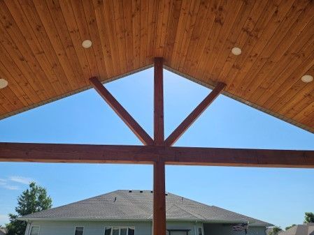 A house with a wooden roof and a blue sky in the background.