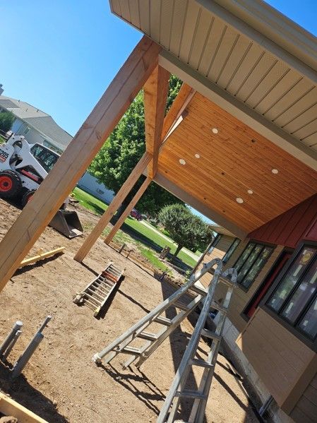 A ladder is sitting in front of a house under construction.