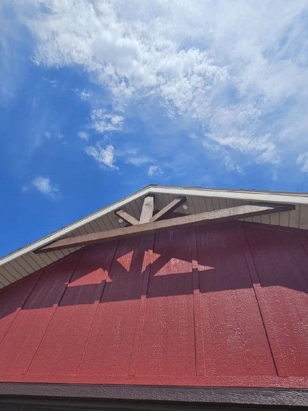 A red barn with a blue sky in the background.
