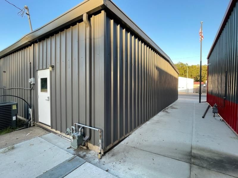 A gray metal building with a white door