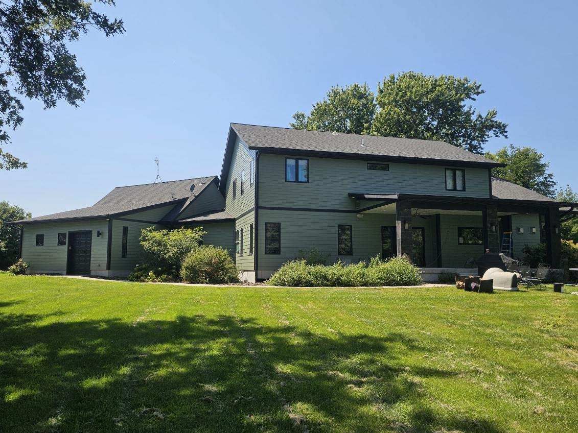 A large, newly painted house is sitting on top of a lush green field