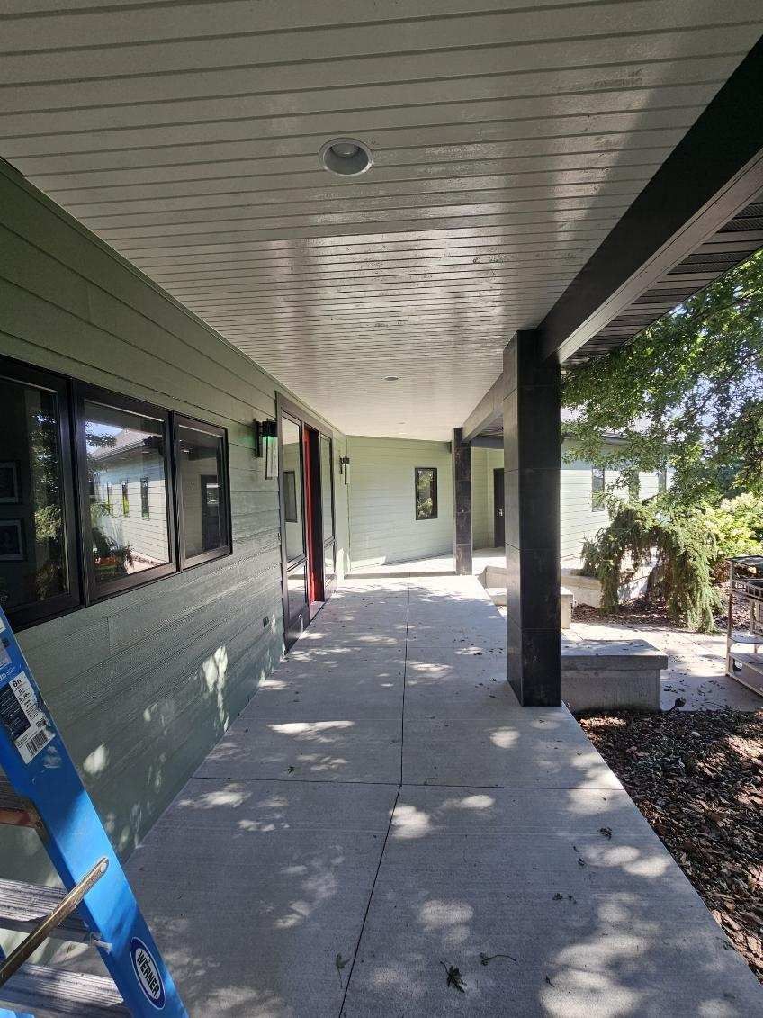 A long hallway leading to a house with a ladder in the foreground