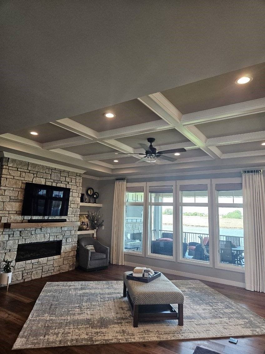 A living room with a fireplace , television , rug and ceiling fan.