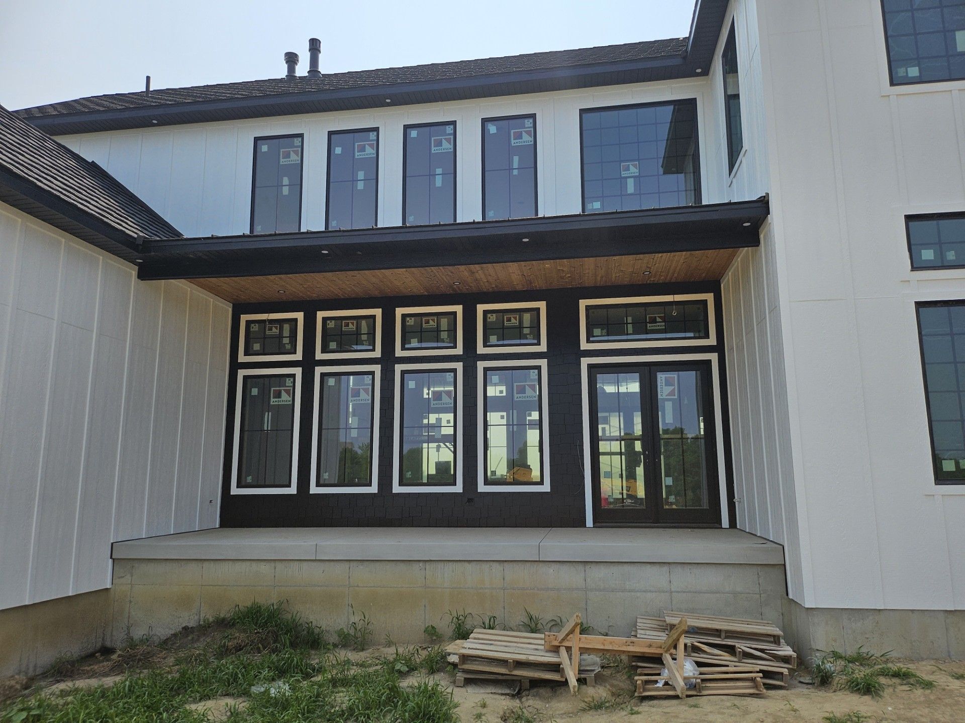 A large white house with a lot of windows is being built.