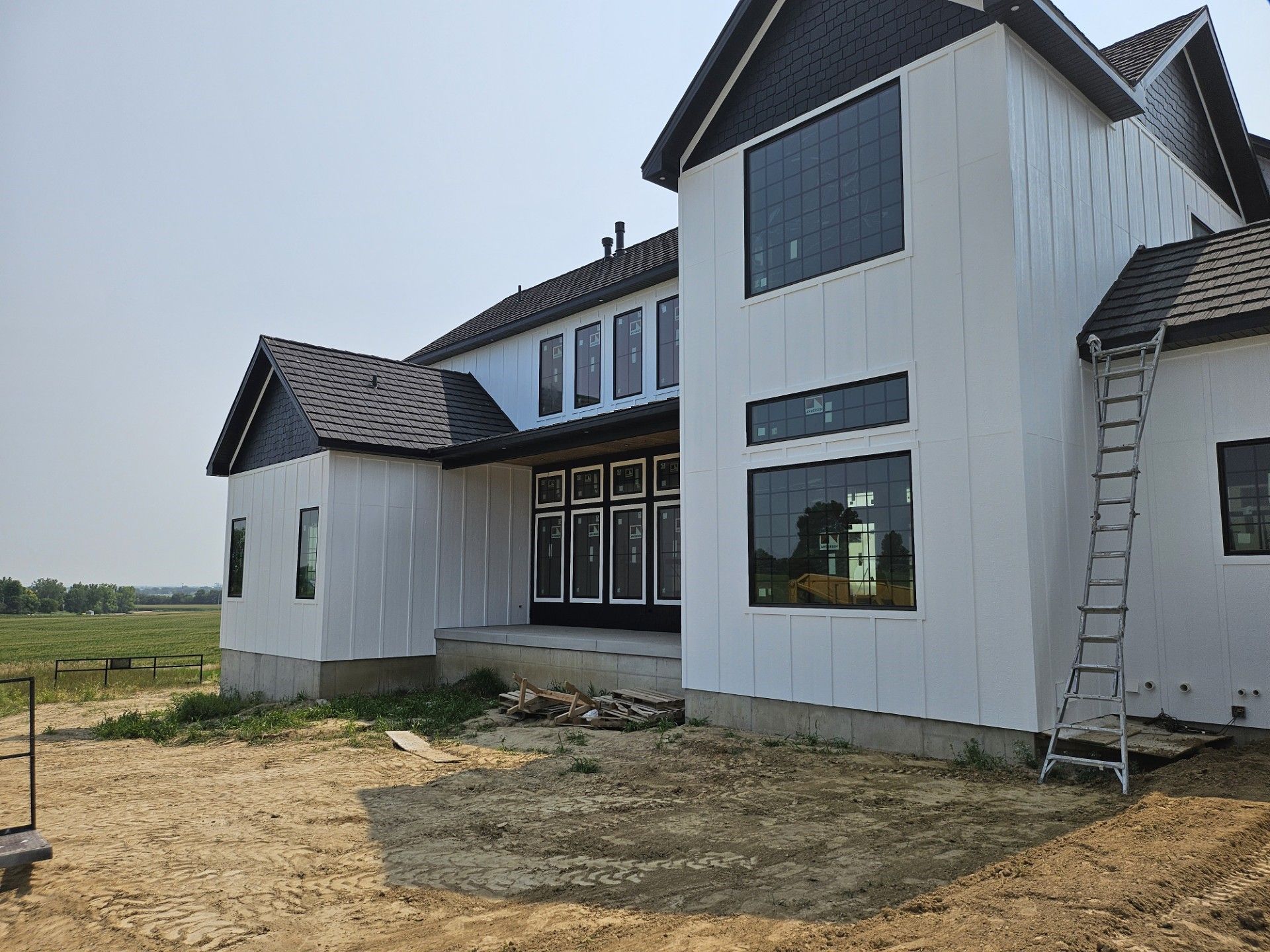 A large white house with a ladder in front of it is being built.