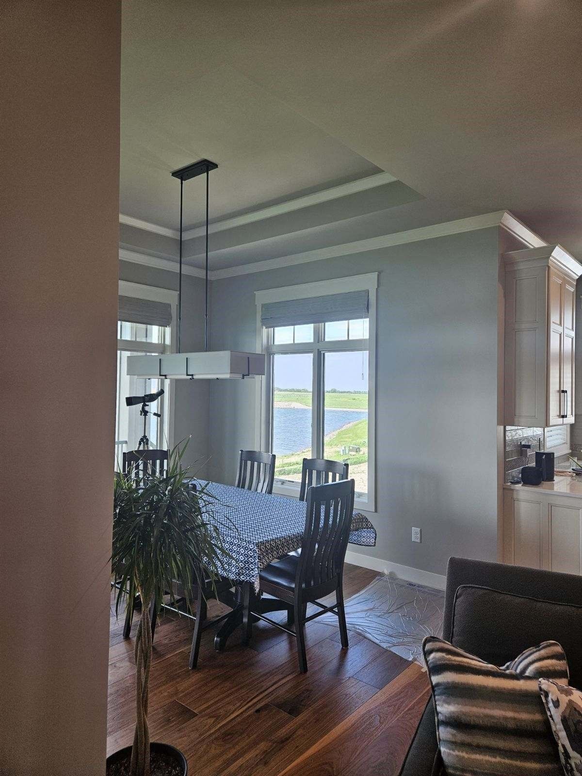 A living room with a table and chairs and a view of the ocean.