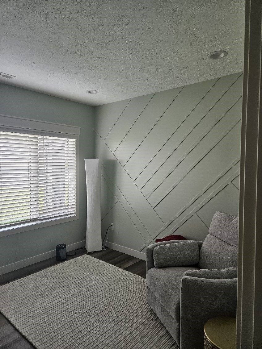 A living room with a couch , chair , rug and window.