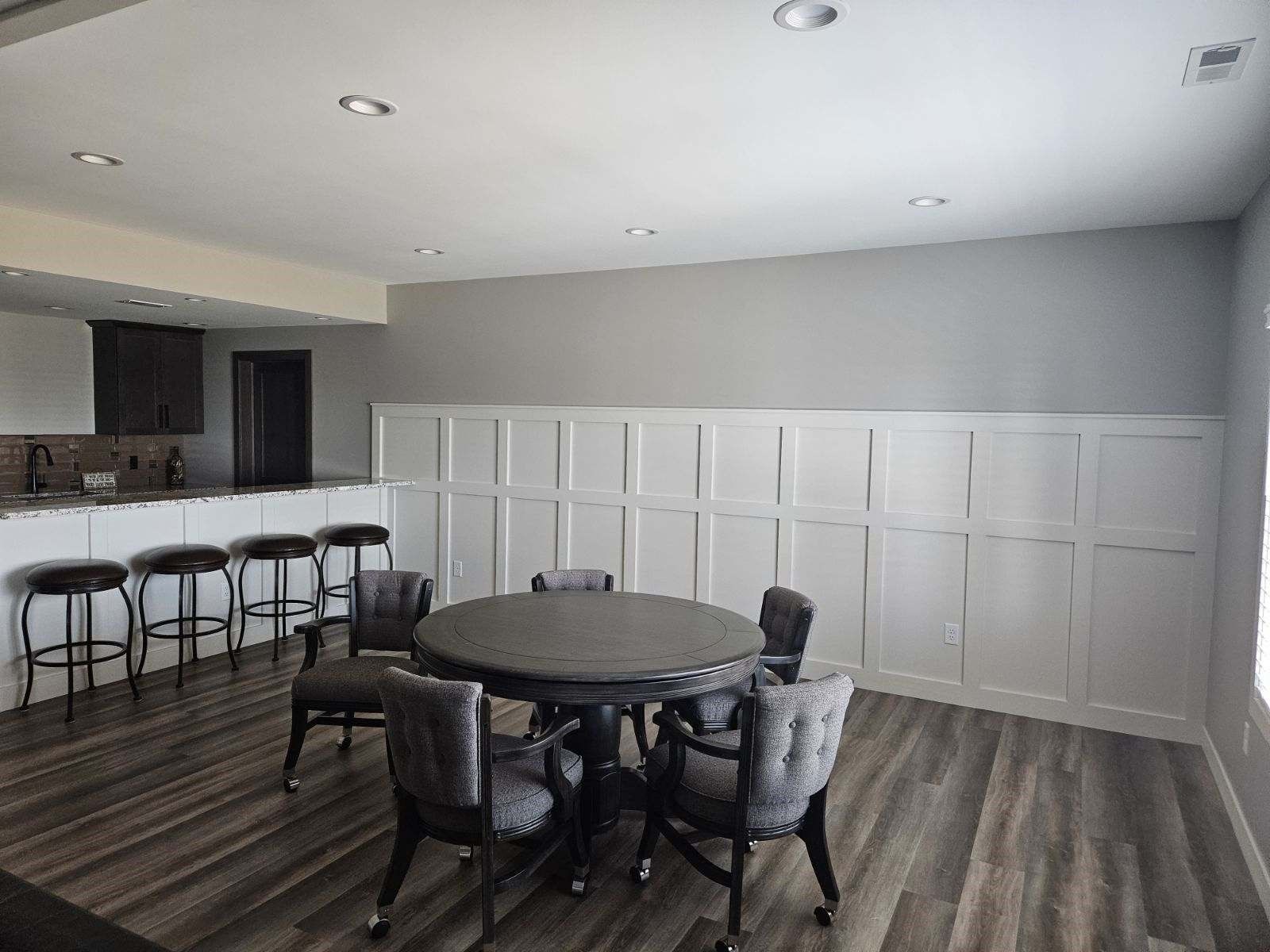 There is a table and chairs in the middle of the room.