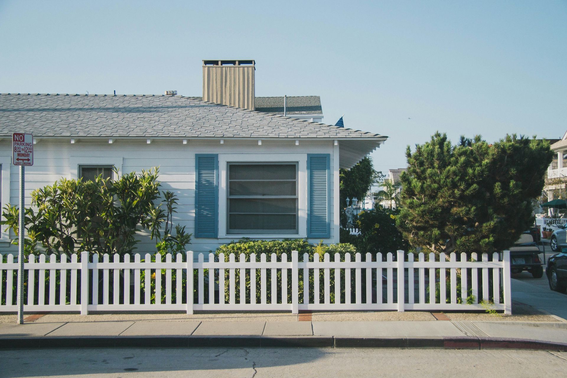 A white house with a white picket fence in front of it.