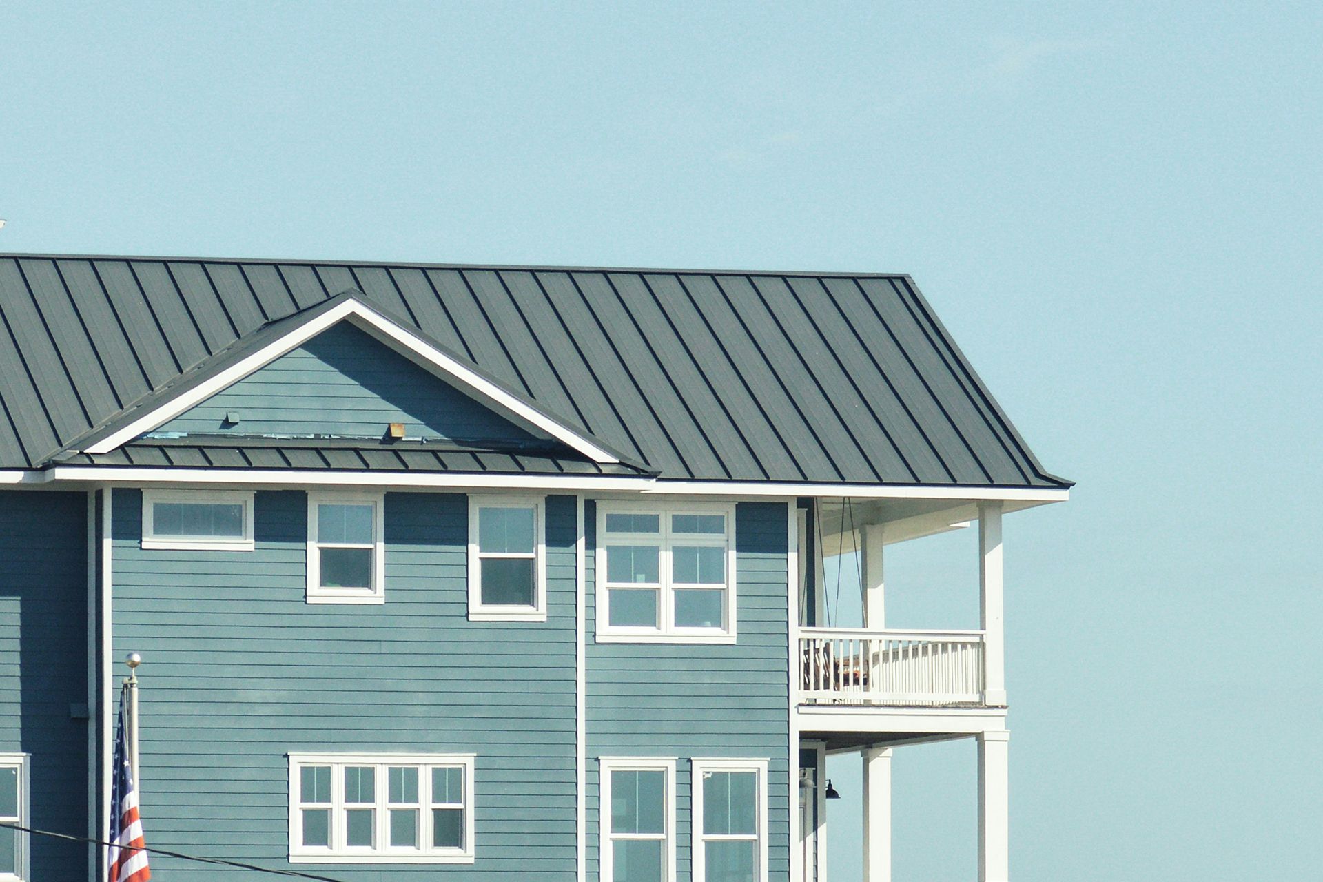 A blue house with a black roof and white trim