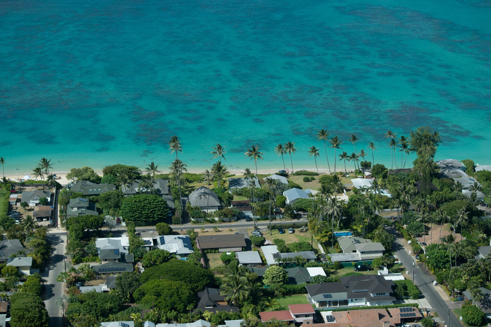 An aerial view of a residential area with a beach in the background