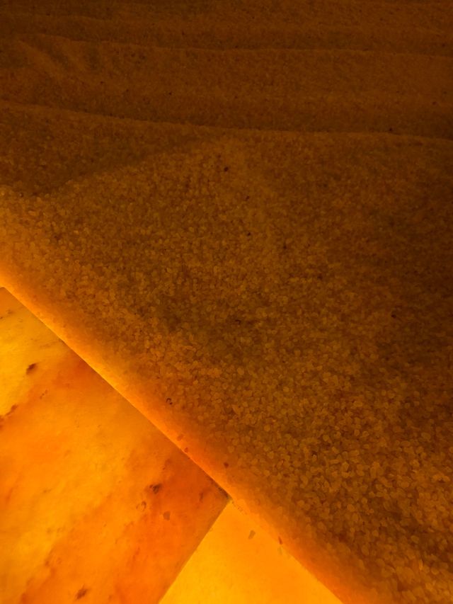 Close-up of a brown carpeted floor meeting a warm orange tiled surface.