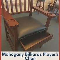 Mahogany billiards player’s chair with padded seat and armrests in a showroom