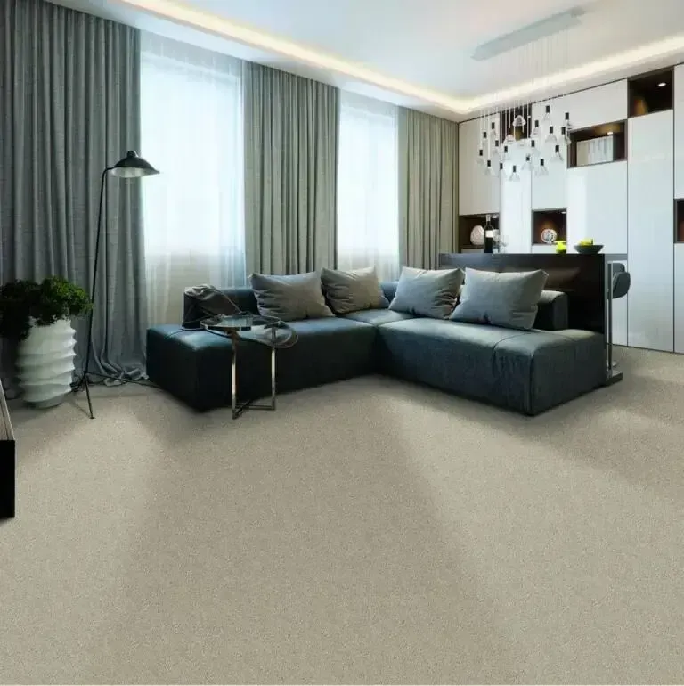 Living room with gray sofa, neutral carpet, large windows, and modern decor.