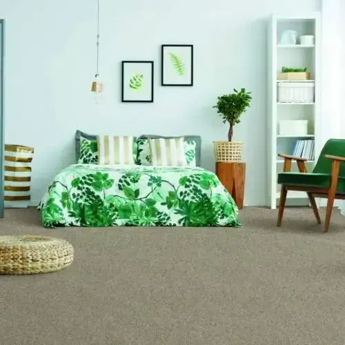 Bedroom with green floral bedding, neutral carpet, and green accents.