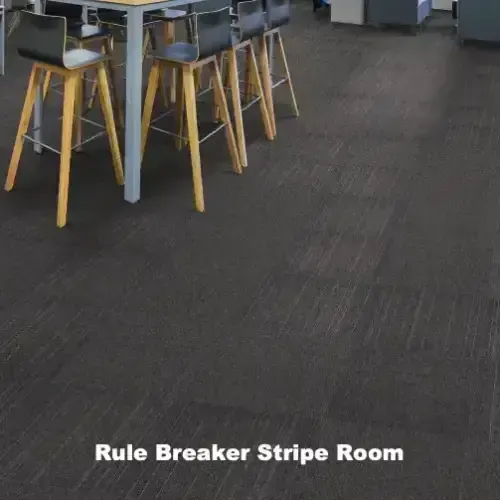 Dark room with a table, bar stools, and carpet labeled “Rule Breaker Stripe Room.”