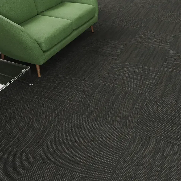 Green sofa on dark patterned carpet; corner view.