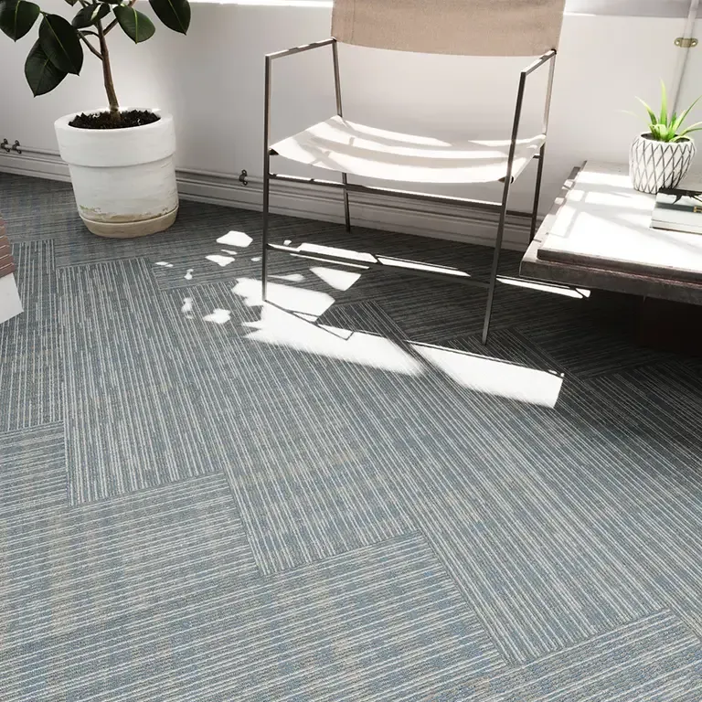 Light blue carpet tiles, chair, potted plants, side table, window.