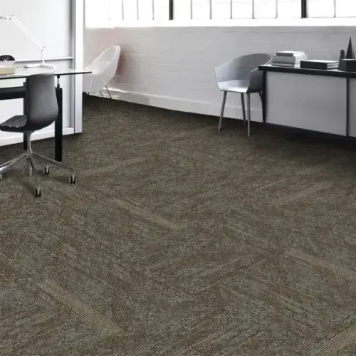 Office interior with neutral-toned carpet, desk, chairs, and window with natural light.