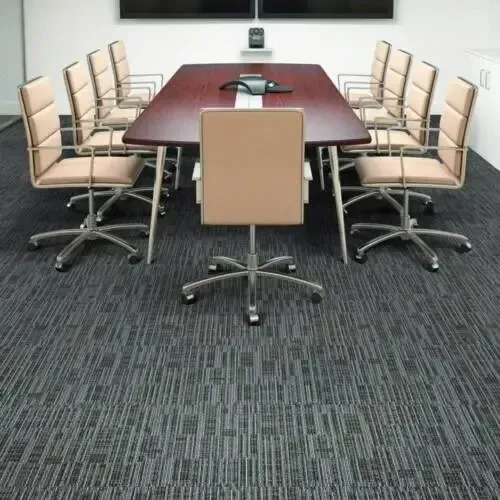 Conference room with a dark wooden table, tan chairs, and patterned gray carpet.
